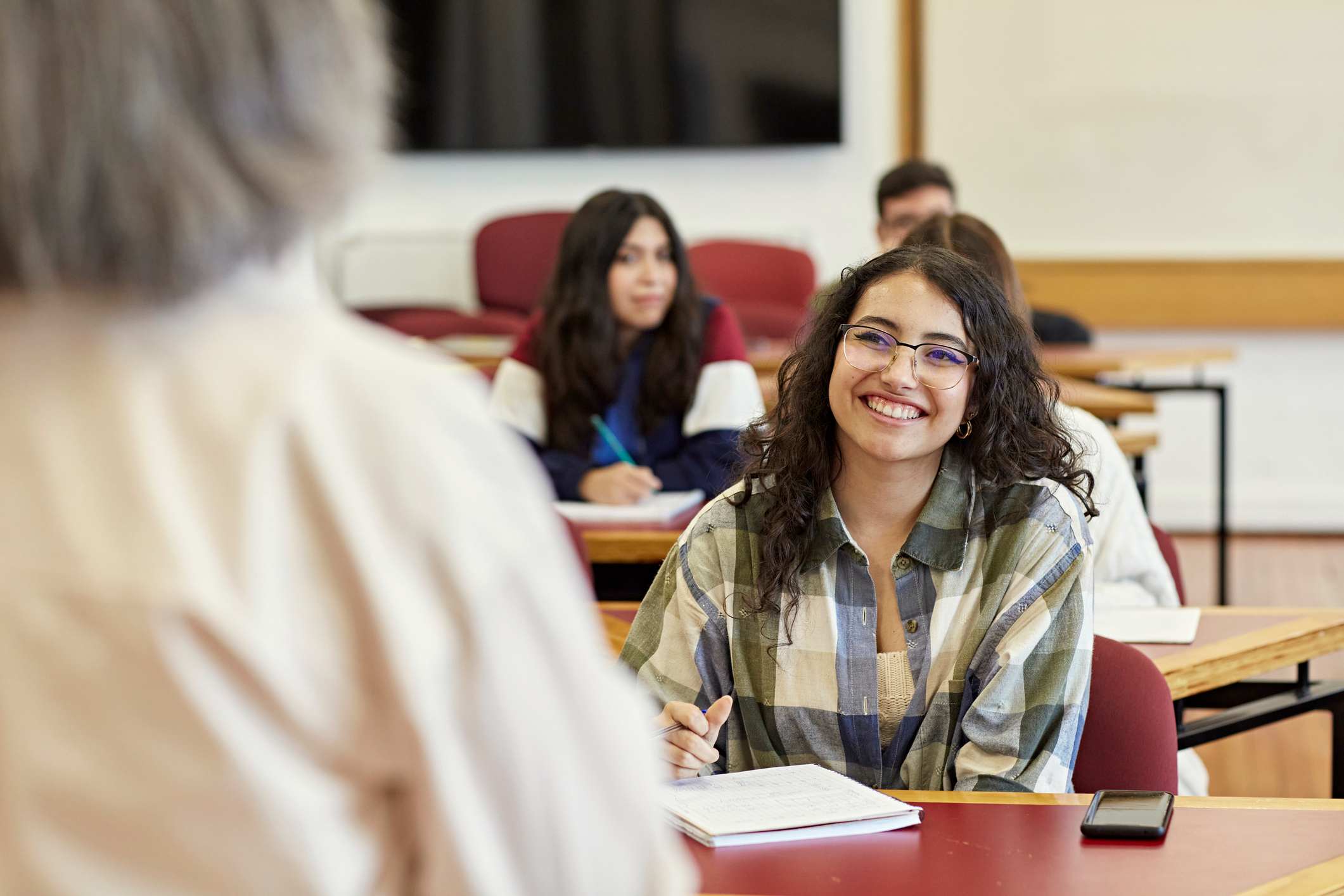 girl smiles while taking notes